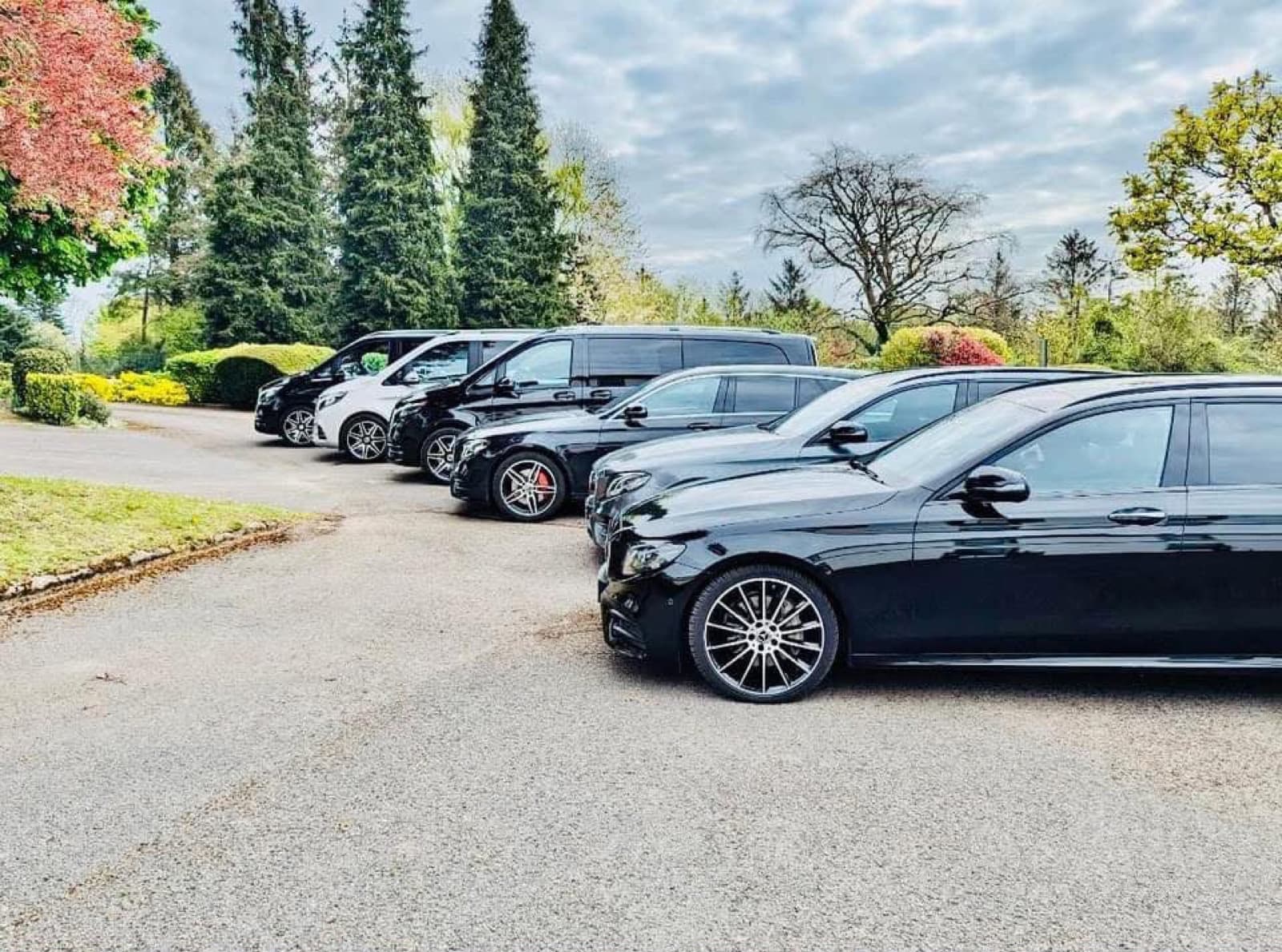 MGM Travels fleet — black Mercedes E-Class and V-Class lined up, executive chauffeur vehicles